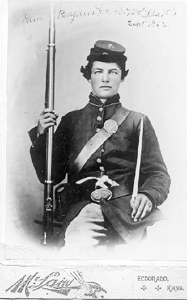 A hard-eyed Illinois Union soldier pictured with his rifle and a large pistol tucked into his belt. The photo was taken in Kansas.